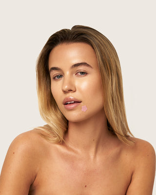 Girl with bare natural face wearing bloomies pimple patch